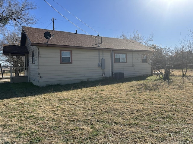 rear view of house with a yard and central air condition unit