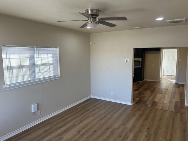 empty room featuring ceiling fan and dark wood-type flooring