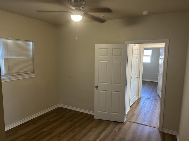 empty room featuring ceiling fan and dark wood-type flooring