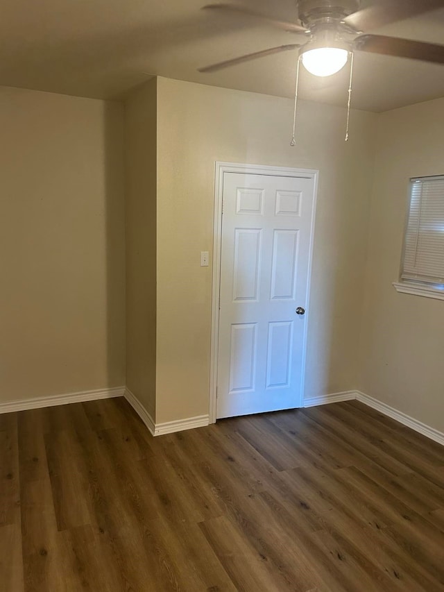 unfurnished room with ceiling fan and dark wood-type flooring