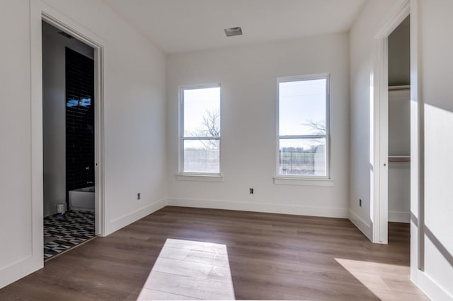 unfurnished bedroom featuring connected bathroom and light hardwood / wood-style floors