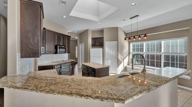 kitchen featuring sink, hanging light fixtures, white refrigerator, backsplash, and a kitchen island