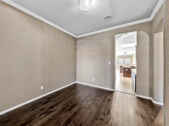 unfurnished room with crown molding, wood-type flooring, and a textured ceiling