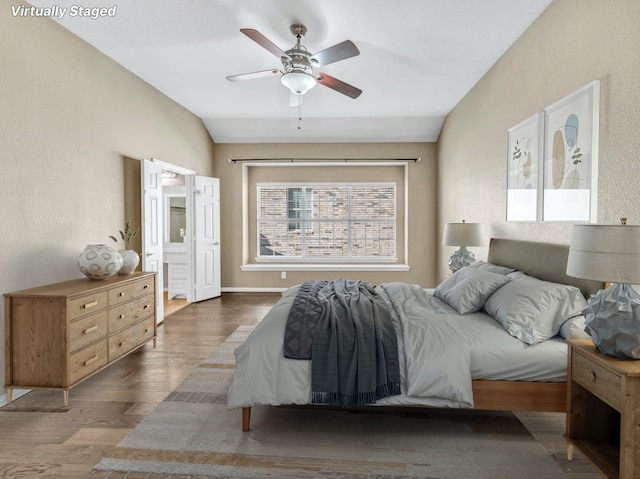 bedroom with dark hardwood / wood-style floors, ceiling fan, and lofted ceiling