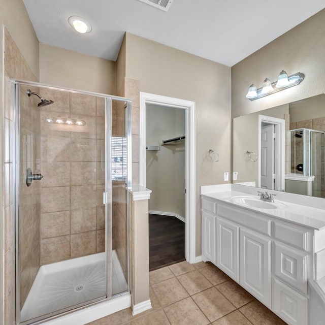 bathroom featuring tile patterned floors, vanity, and walk in shower