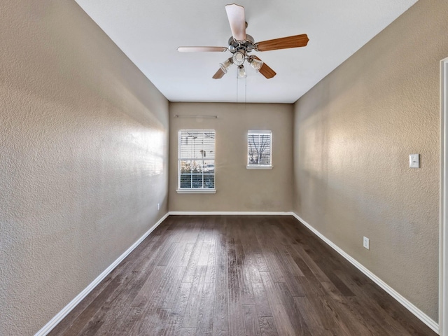 unfurnished room with ceiling fan and dark wood-type flooring