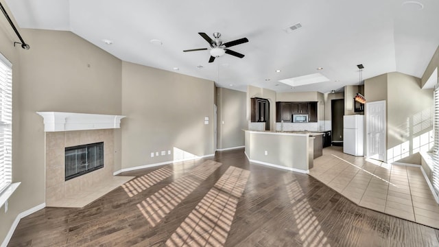 living room with a tiled fireplace, ceiling fan, and hardwood / wood-style flooring