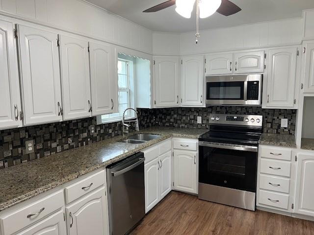 kitchen featuring backsplash, white cabinetry, sink, and appliances with stainless steel finishes