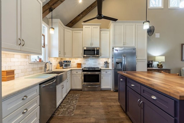 kitchen featuring white cabinets, appliances with stainless steel finishes, wood counters, and pendant lighting