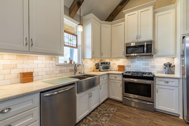 kitchen featuring white cabinetry, sink, dark wood-type flooring, decorative backsplash, and appliances with stainless steel finishes