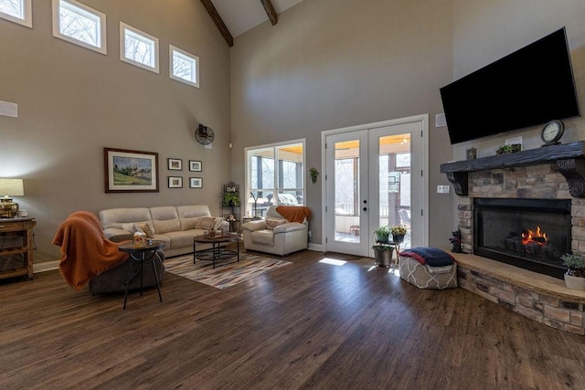 living room with a high ceiling, french doors, dark hardwood / wood-style floors, a fireplace, and beam ceiling