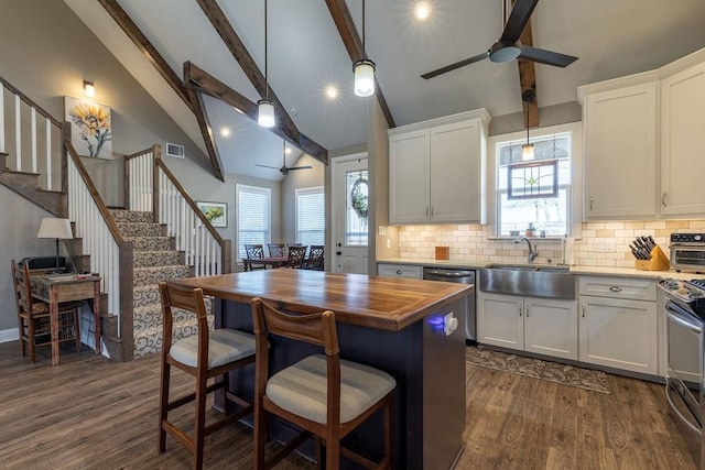 kitchen featuring white cabinets, ceiling fan, beam ceiling, and sink