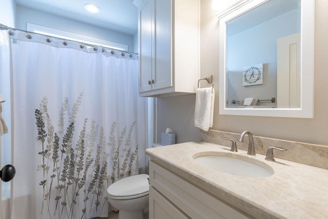 bathroom featuring a shower with curtain, vanity, and toilet