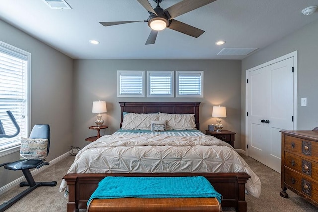 bedroom with a closet, light colored carpet, and ceiling fan