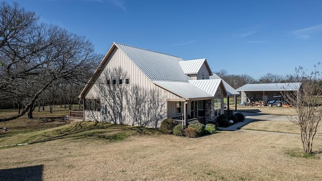 view of side of property featuring a lawn and a porch