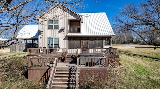 rear view of property with a lawn and a sunroom