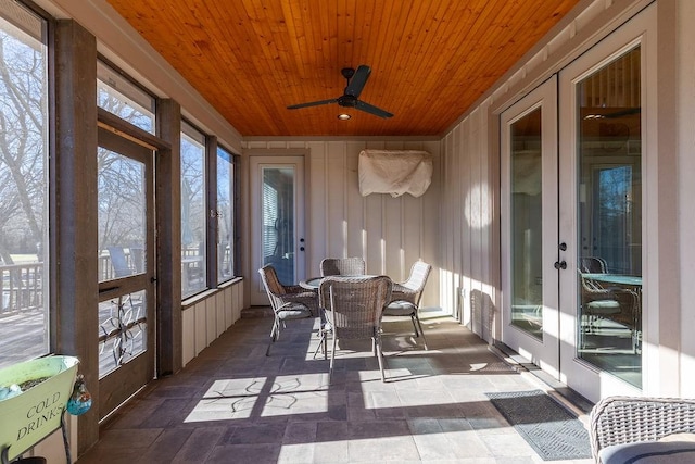 sunroom featuring plenty of natural light, ceiling fan, wood ceiling, and french doors