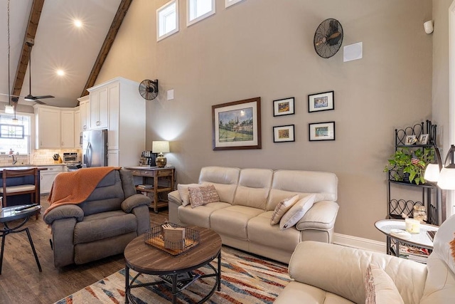 living room with high vaulted ceiling, sink, hardwood / wood-style flooring, ceiling fan, and beam ceiling