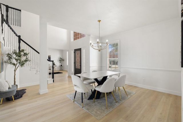 dining room featuring light hardwood / wood-style flooring, ornamental molding, and a chandelier