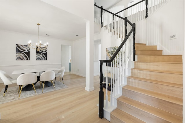 interior space featuring wood-type flooring, a chandelier, and ornamental molding