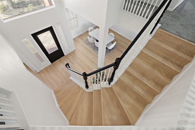 stairs with a high ceiling and wood-type flooring