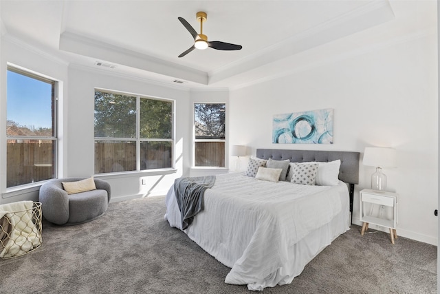 carpeted bedroom featuring ceiling fan, ornamental molding, and a tray ceiling