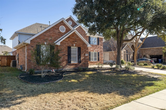 view of property featuring a front lawn and central AC