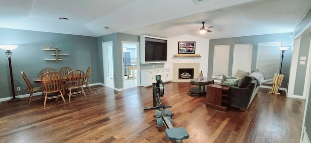 living room featuring ceiling fan, a fireplace, dark hardwood / wood-style floors, and lofted ceiling