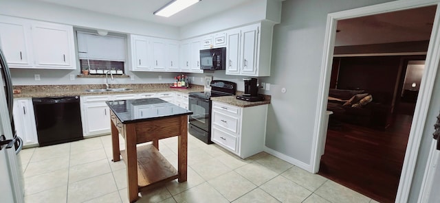 kitchen featuring sink, white cabinetry, dark stone counters, and black appliances