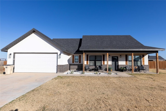 view of front of home with a garage, a front yard, a patio, and covered porch