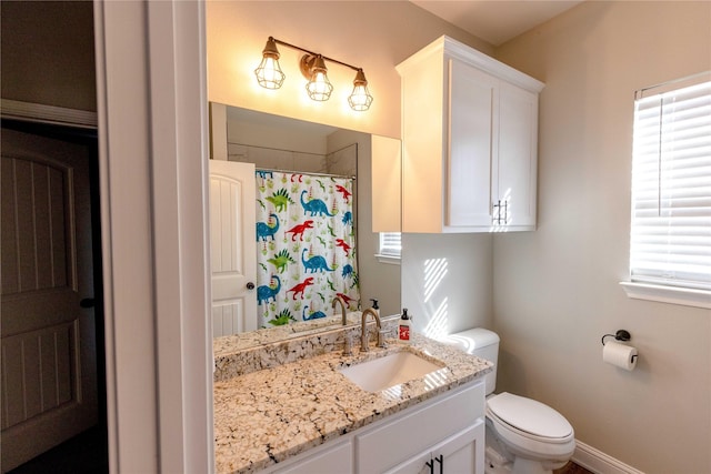 bathroom with walk in shower, vanity, and toilet