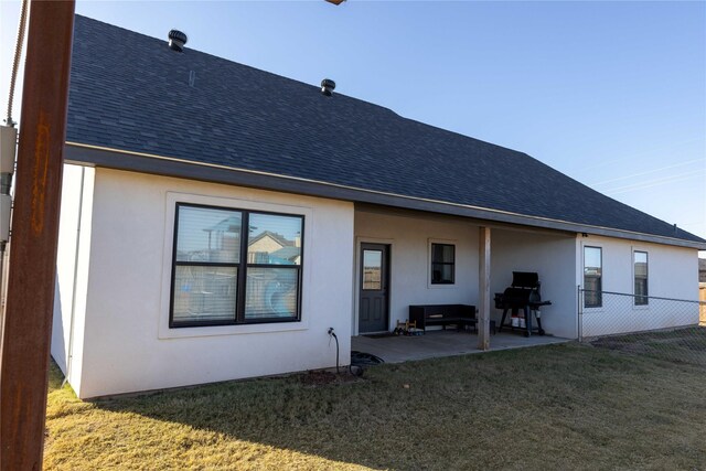 rear view of property featuring a yard and a patio