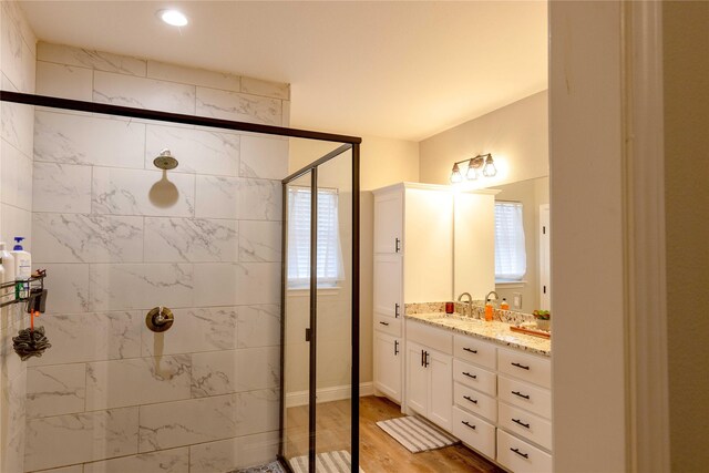 bathroom featuring hardwood / wood-style floors, vanity, and walk in shower