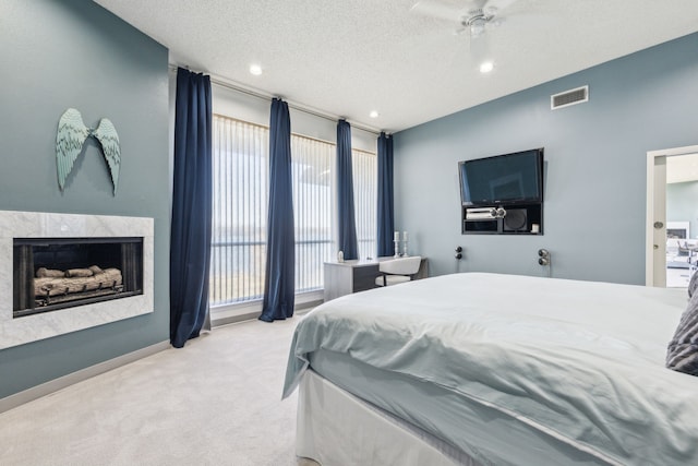 carpeted bedroom with ceiling fan and a textured ceiling