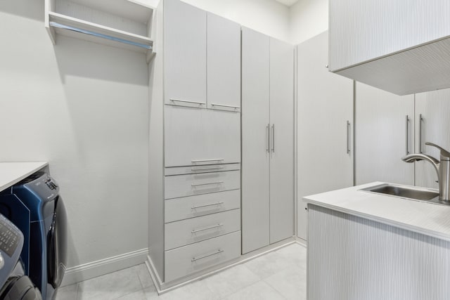 washroom featuring washer / clothes dryer, sink, and cabinets