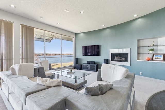 living room featuring built in shelves, light colored carpet, and a textured ceiling