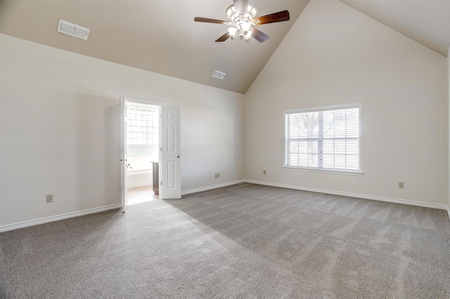 carpeted spare room with high vaulted ceiling, ceiling fan, and a healthy amount of sunlight