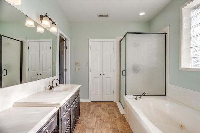 bathroom with vanity and shower with separate bathtub