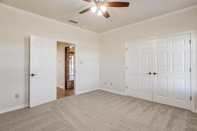 unfurnished bedroom featuring carpet flooring, ceiling fan, a closet, and ornamental molding