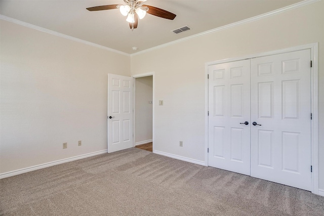 unfurnished bedroom with carpet flooring, a closet, ceiling fan, and ornamental molding