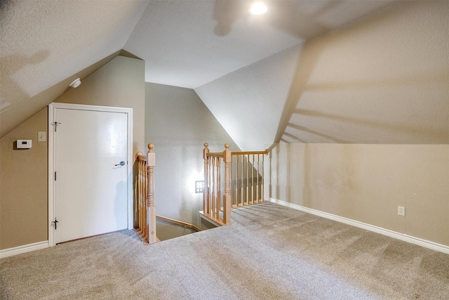 bonus room featuring carpet flooring, a textured ceiling, and vaulted ceiling