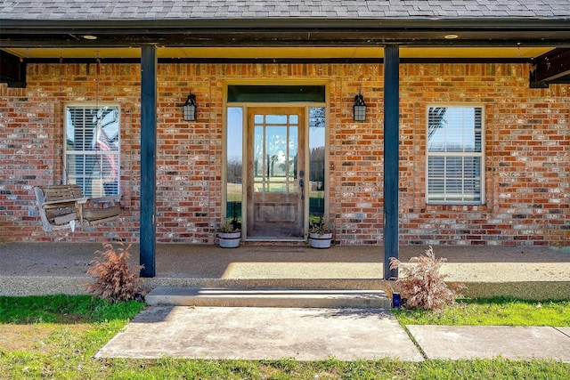 view of exterior entry featuring covered porch