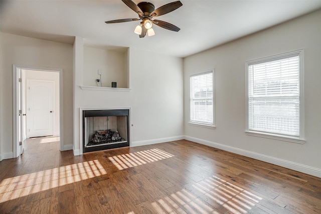 unfurnished living room with wood-type flooring and ceiling fan