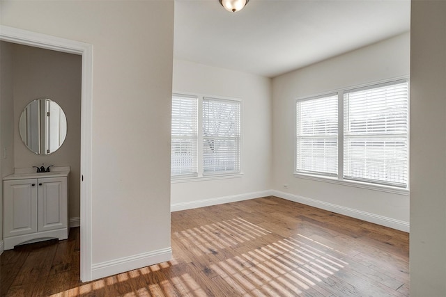 spare room featuring sink and hardwood / wood-style flooring