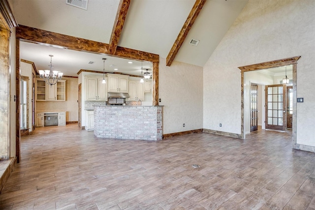 unfurnished living room with a chandelier, beam ceiling, and high vaulted ceiling