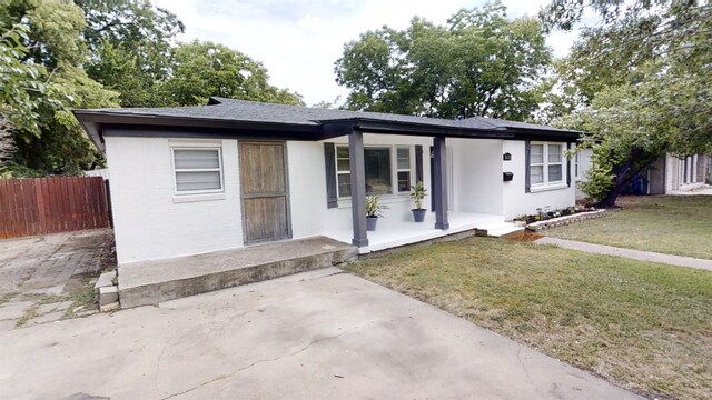 view of front of house with covered porch and a front lawn