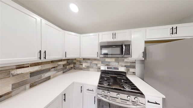 kitchen with decorative backsplash, stainless steel appliances, and white cabinetry