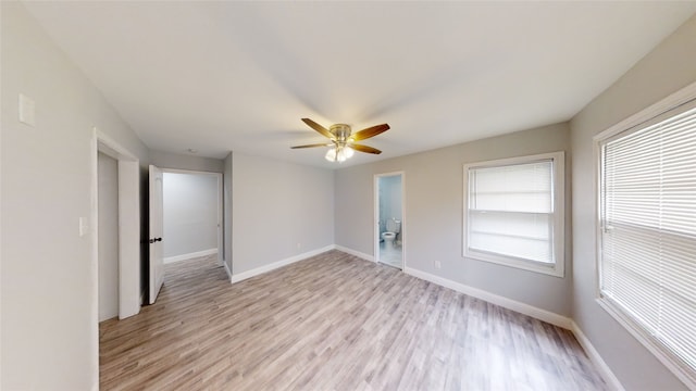 empty room with ceiling fan, a healthy amount of sunlight, and light wood-type flooring