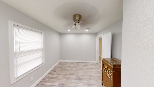 empty room with ceiling fan and light wood-type flooring