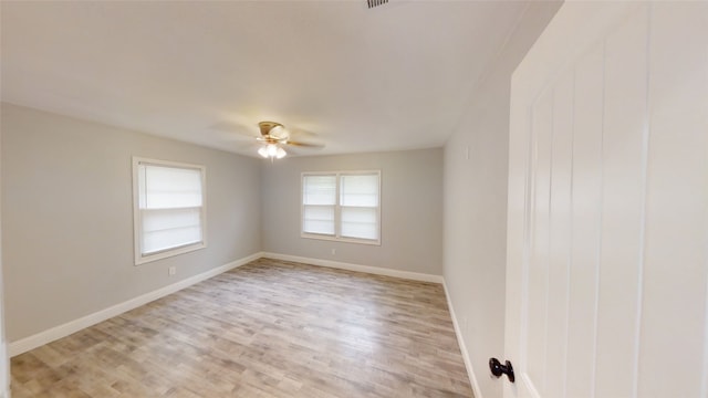 empty room featuring ceiling fan, plenty of natural light, and light hardwood / wood-style flooring